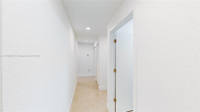 hall with light tile patterned floors