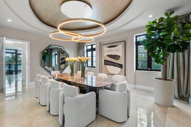 dining area with a tray ceiling and a wealth of natural light