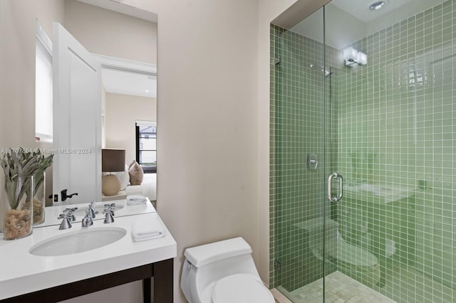 bathroom featuring vanity, toilet, and a shower with door