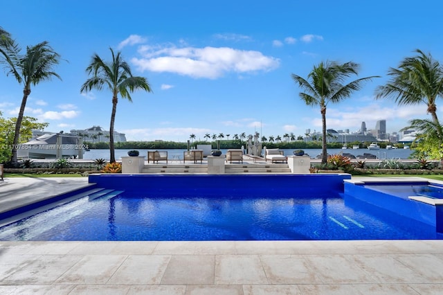 view of pool with an in ground hot tub and a water view