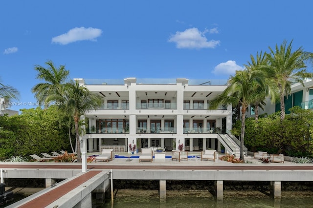 rear view of property featuring a balcony, a swimming pool, and a patio