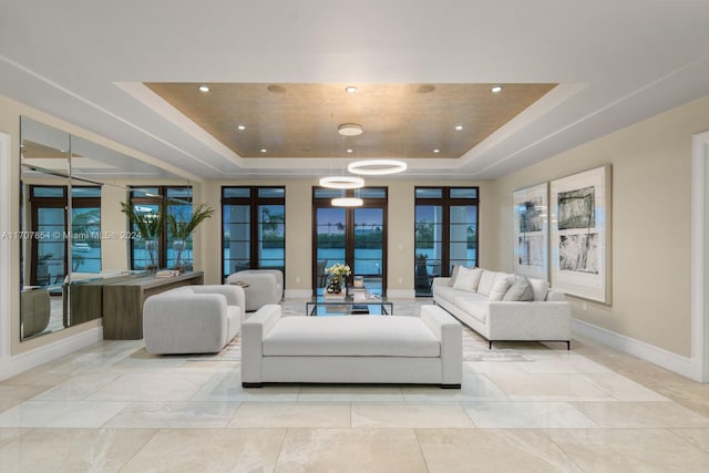 living room with a tray ceiling and french doors