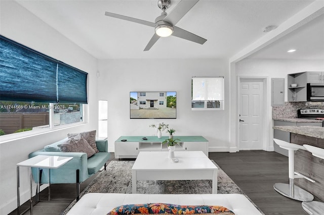 living room featuring dark hardwood / wood-style flooring and ceiling fan