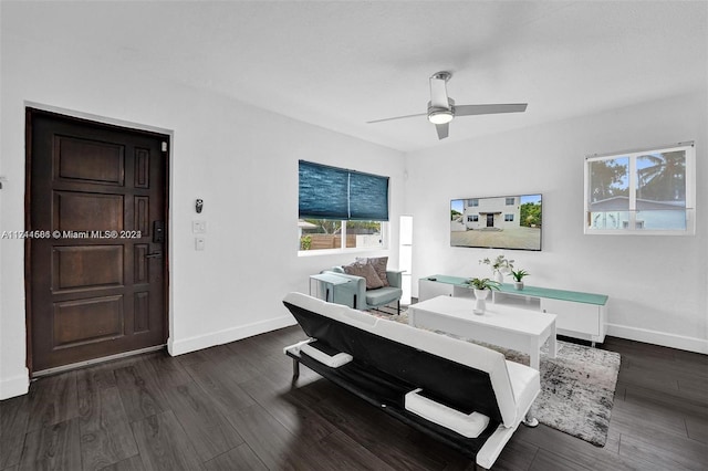 living room with ceiling fan and dark wood-type flooring