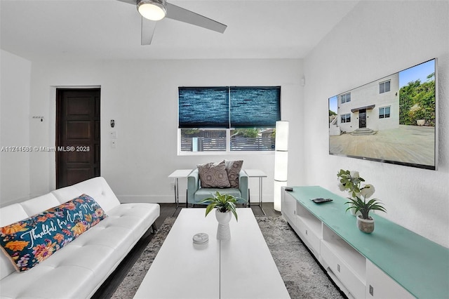 living room featuring dark hardwood / wood-style flooring and ceiling fan