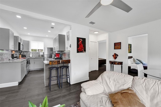 living room featuring dark hardwood / wood-style floors and ceiling fan