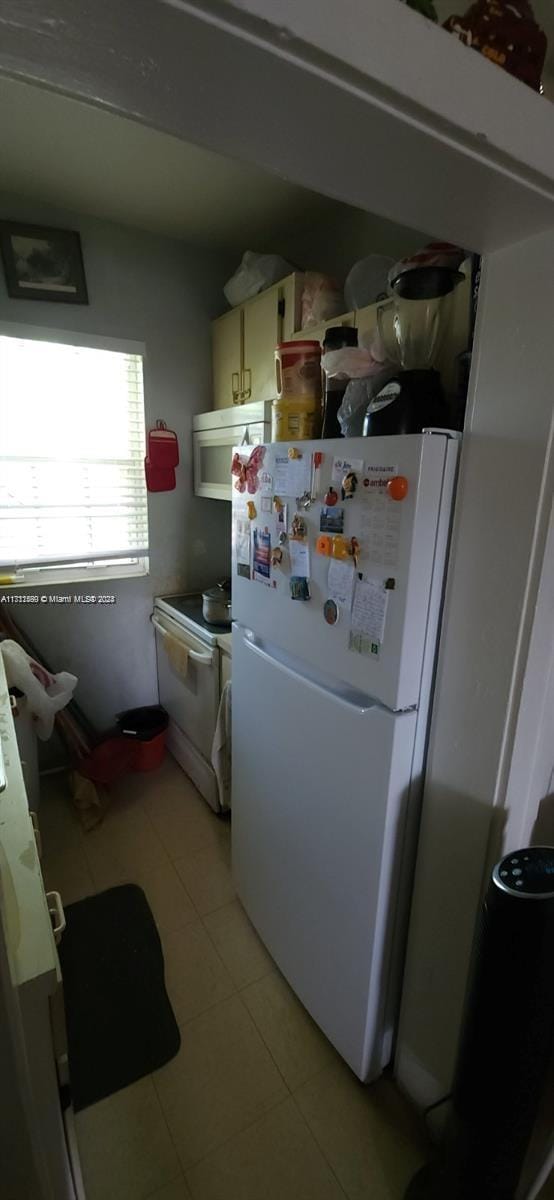 251 NW 34th Ter, Miami, FL 33127 - kitchen featuring white appliances and light tile patterned floors