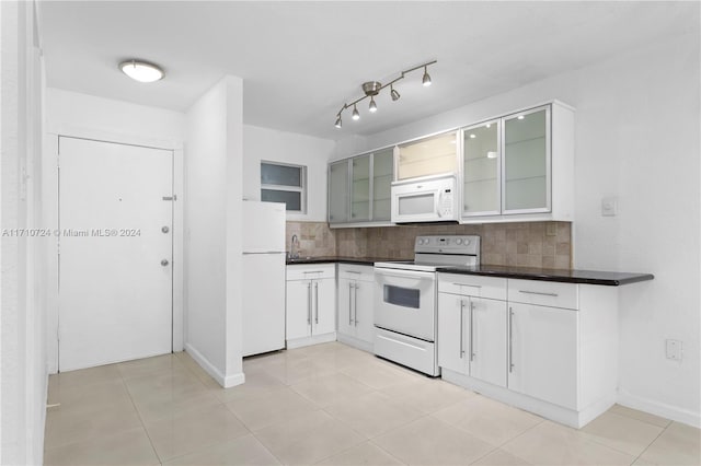 kitchen featuring sink, tasteful backsplash, light tile patterned flooring, white appliances, and white cabinets