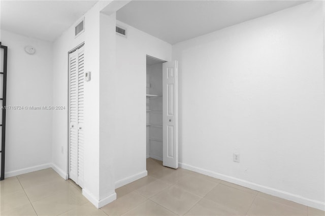 unfurnished bedroom featuring light tile patterned floors and a closet