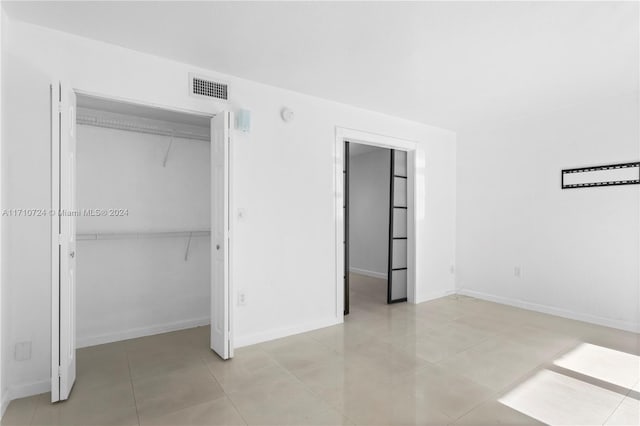 unfurnished bedroom with a closet and light tile patterned floors