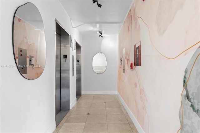 corridor with elevator and light tile patterned floors