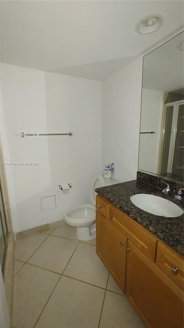 full bathroom with vanity, tile patterned floors, toilet, and a shower stall