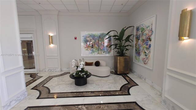 sitting room with baseboards, marble finish floor, and ornamental molding