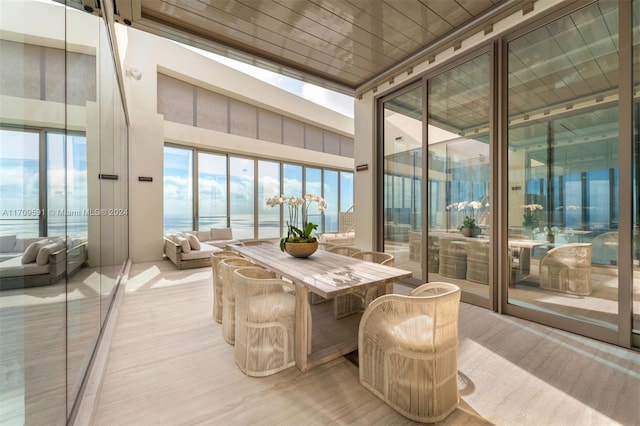 sunroom / solarium with a healthy amount of sunlight, a water view, and a skylight