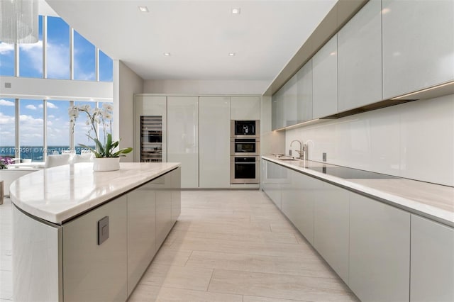 kitchen featuring black electric stovetop, light hardwood / wood-style flooring, and sink