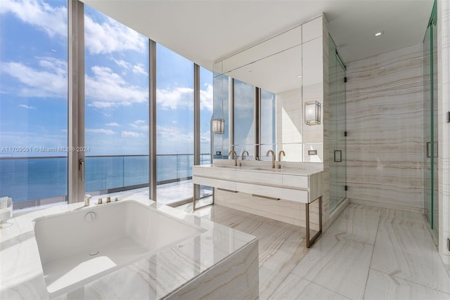 bathroom featuring vanity, a water view, floor to ceiling windows, and independent shower and bath