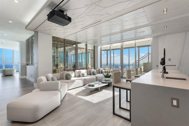 living room featuring expansive windows, light hardwood / wood-style floors, and sink