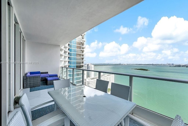 balcony featuring an outdoor living space and a water view