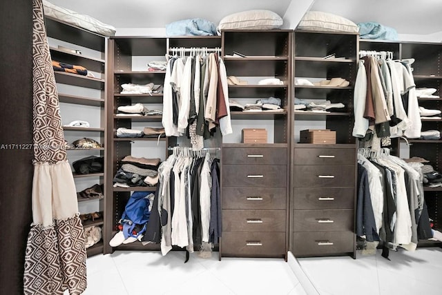 walk in closet with light tile patterned floors