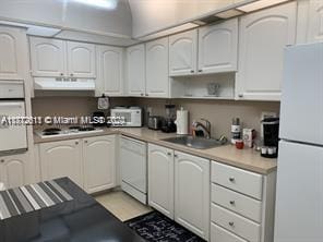 kitchen with white cabinets, white appliances, sink, and exhaust hood