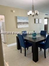 dining space with light tile patterned floors and an inviting chandelier