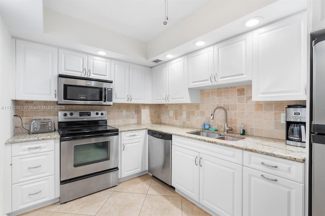 kitchen featuring stainless steel appliances, white cabinetry, tasteful backsplash, and sink