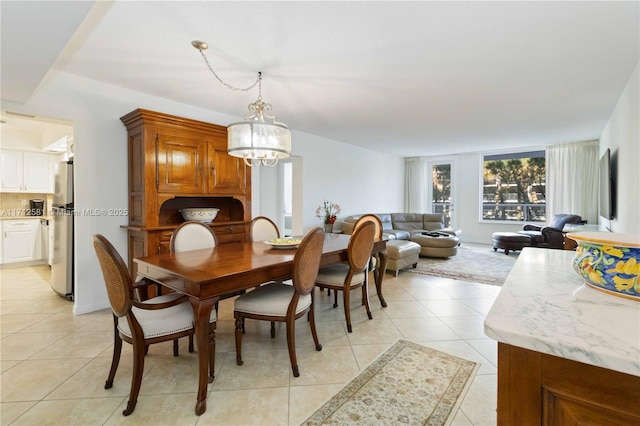 tiled dining room featuring a chandelier