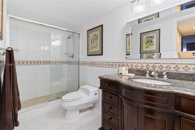 bathroom featuring vanity, a shower with shower door, tile walls, and toilet