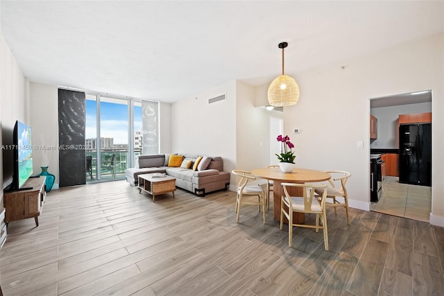 living room featuring floor to ceiling windows and light hardwood / wood-style floors