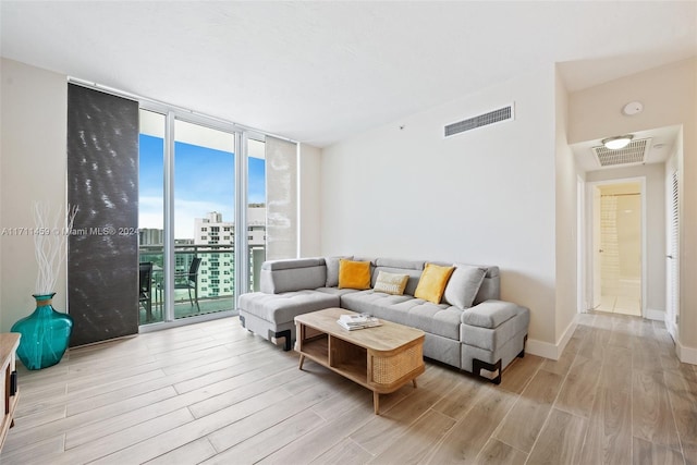 living room featuring a wealth of natural light, expansive windows, and light wood-type flooring