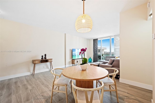 dining space featuring wood-type flooring and floor to ceiling windows