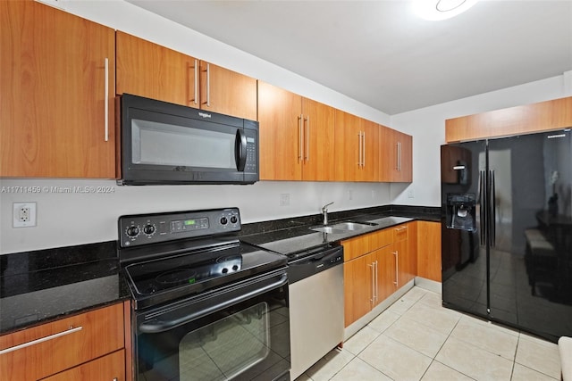 kitchen featuring dark stone countertops, sink, light tile patterned flooring, and black appliances