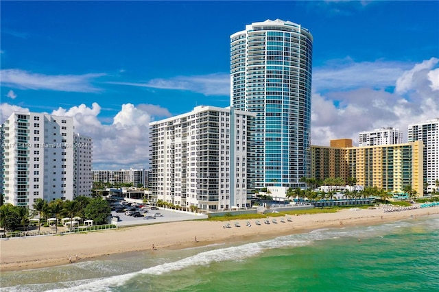 view of building exterior featuring a water view and a beach view