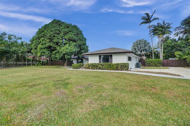 exterior space featuring cooling unit and a front lawn