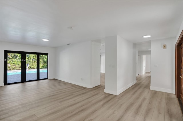 empty room featuring french doors and light wood-type flooring