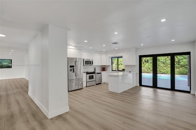 kitchen featuring light hardwood / wood-style floors, white cabinetry, kitchen peninsula, and appliances with stainless steel finishes