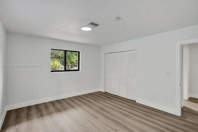 unfurnished bedroom featuring a closet and light hardwood / wood-style flooring