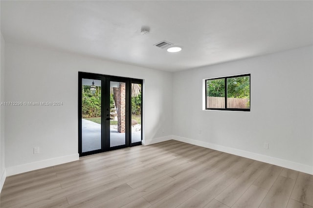 empty room featuring light hardwood / wood-style floors and french doors