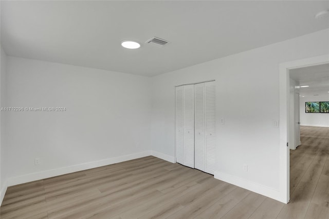 unfurnished bedroom featuring a closet and light hardwood / wood-style floors