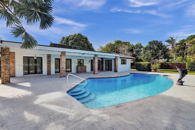 view of swimming pool with a patio area and french doors