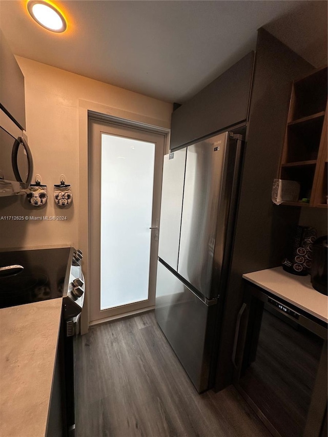 kitchen featuring range, stainless steel refrigerator, beverage cooler, and dark wood-type flooring