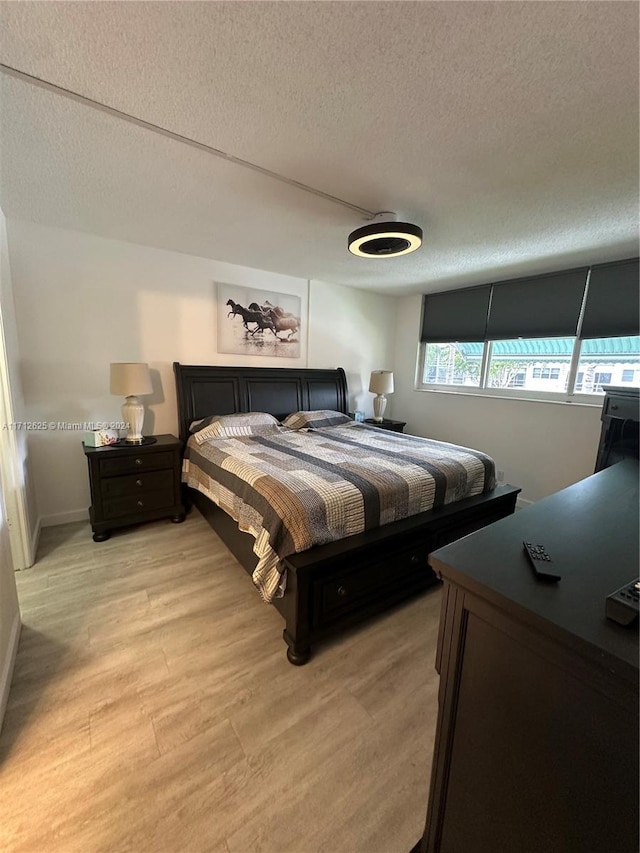 bedroom featuring a textured ceiling and light wood-type flooring