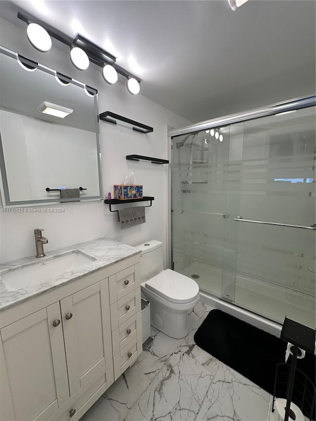 bathroom with toilet, vanity, and walk in shower