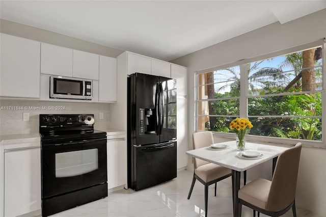 kitchen featuring tasteful backsplash, white cabinetry, and black appliances