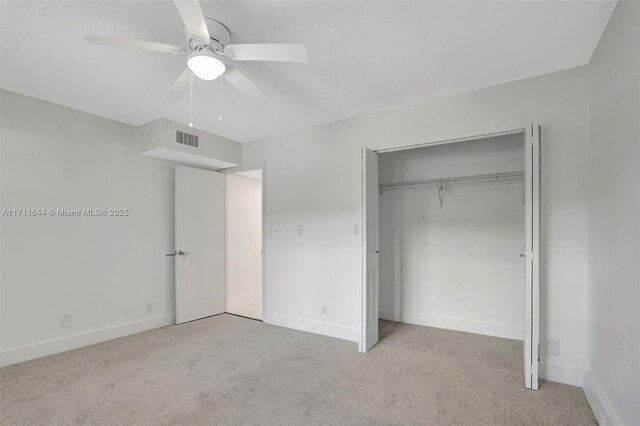 unfurnished bedroom with ceiling fan, a closet, and light carpet