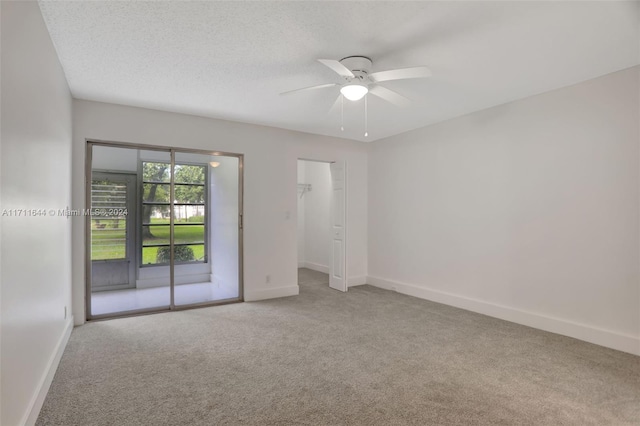 carpeted empty room with a textured ceiling and ceiling fan