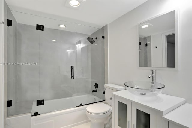 full bathroom featuring vanity, toilet, and combined bath / shower with glass door