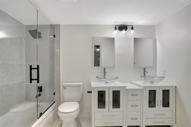 full bathroom featuring vanity, toilet, and bath / shower combo with glass door