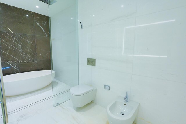 bathroom featuring toilet, sink, and a bidet