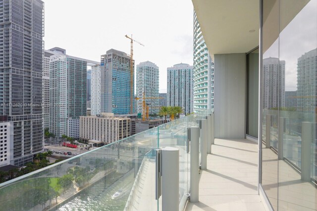 balcony featuring a water view and cooling unit